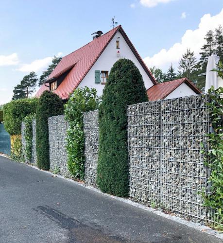 Greenkeepers Gartenbau - Mauer aus Gabionen und Pflanzen als attraktiver Sichtschutz eines Privatgartens